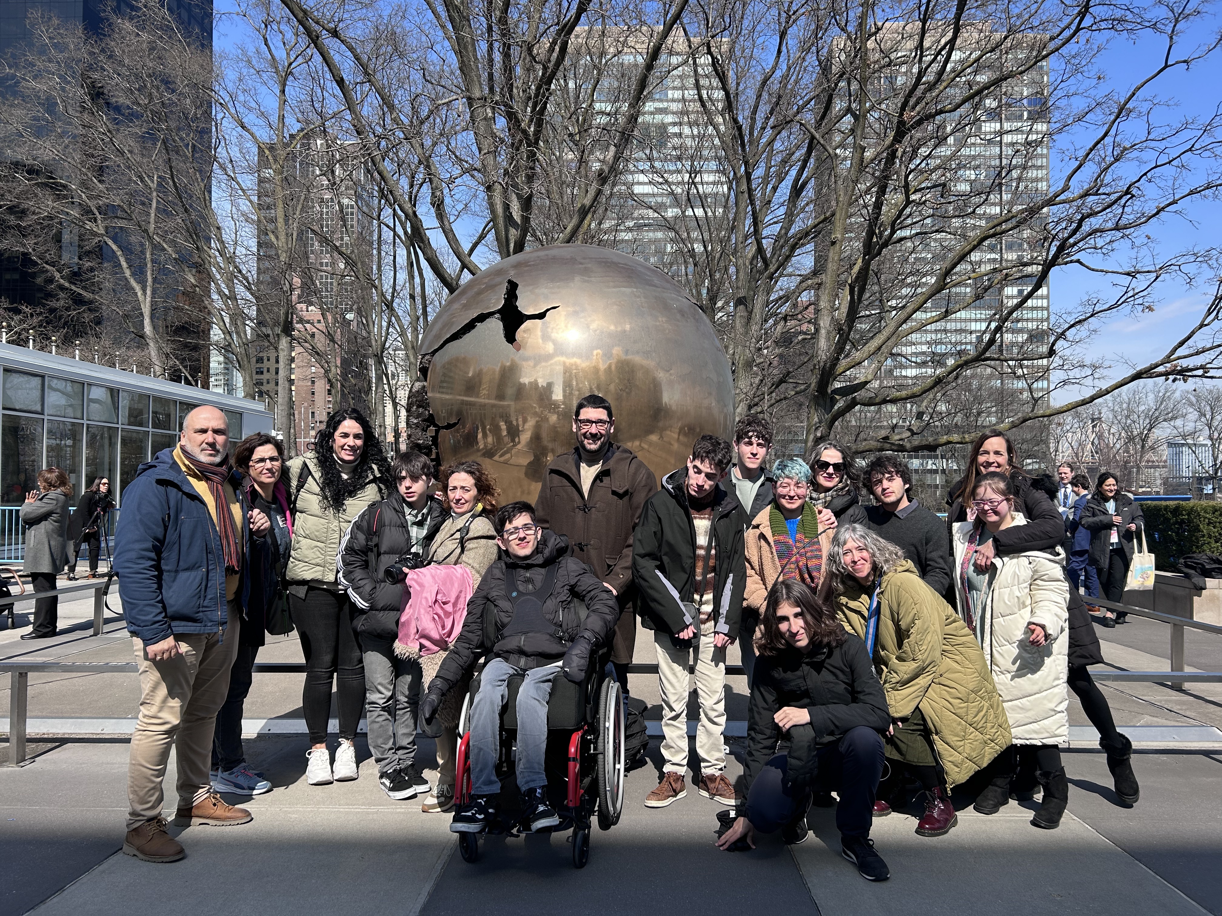 Imagen de todo el grupo delante de la bola del mundo que se describe en el texto