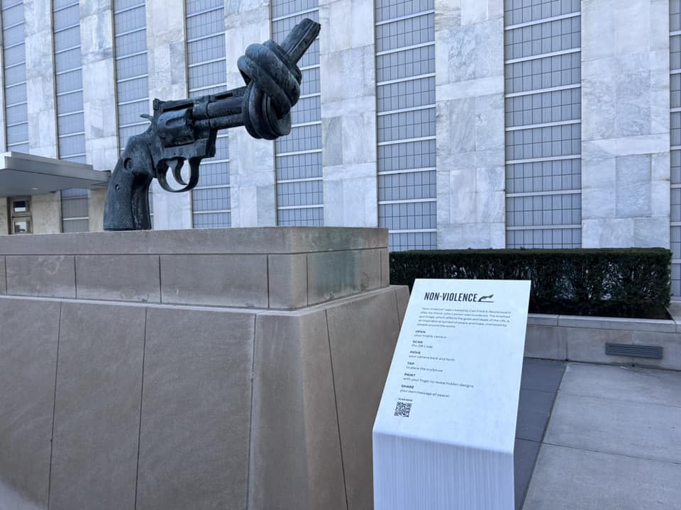 Escultura que se encuentra en el recinto de Naciones Unidas y que representa una pistola con un nudo en el cañón. Aparece un cartel con su título: Non-violence